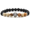 Bracelet pour homme composé d'une élégante tête de lion couleur argent, de perles de pierre de lave et de perles de jaspe scénique.