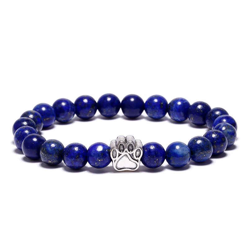 Bracelet pour homme composé d'une élégante patte de chien de couleur argent et de perles d'agate bleue.