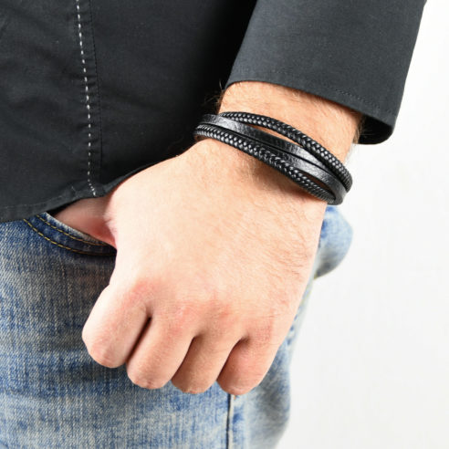 Bracelet pour homme composé de deux lanières de cuir noir tressé et de deux lanières de cuir noir lisse. 