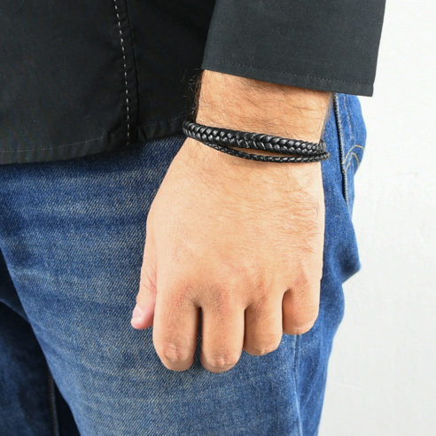 Bracelet pour homme composé de deux lanières de cuir noir tressé.