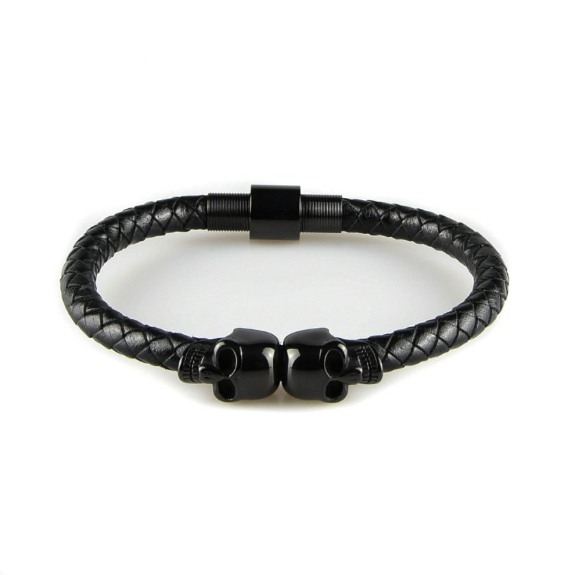 Bracelet pour homme composé d'une lanière de cuir tressé noir et de deux élégants crânes en inox de couleur noire.