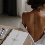 Tatouage dorsale femme fleurs le long de la colonne vertébrale